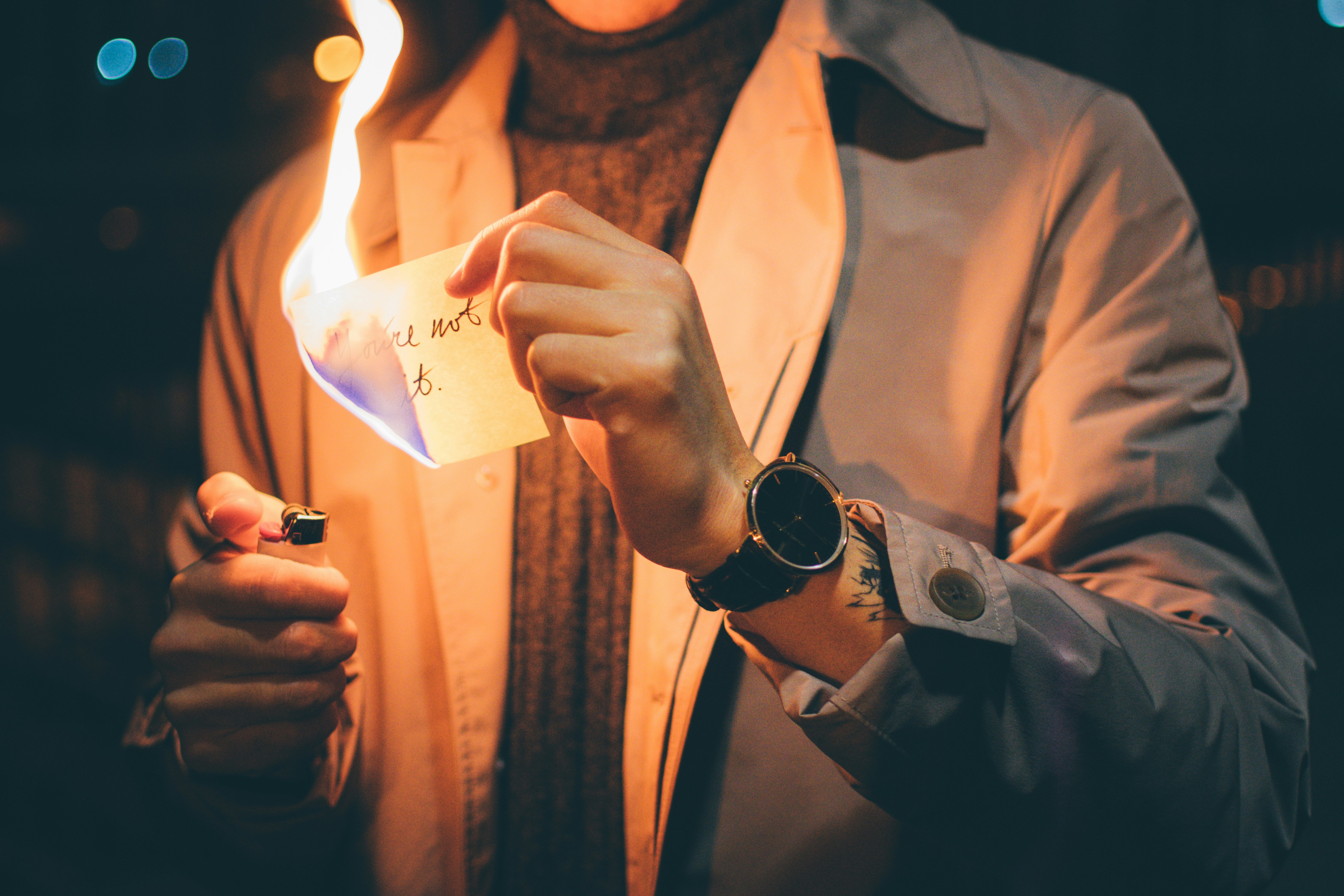 low light photography of person holding paper with flame